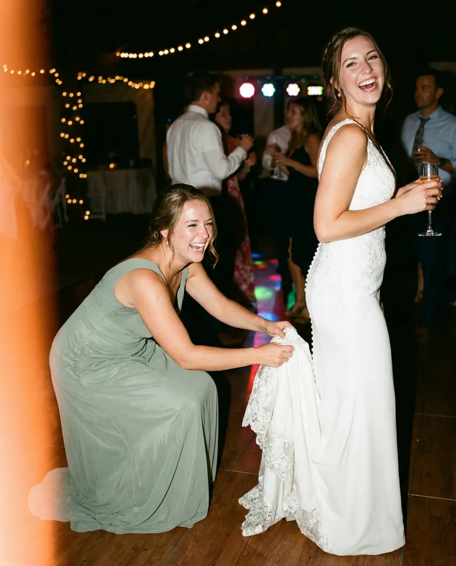The maid of honor bustling the bride’s train on the dance floor.